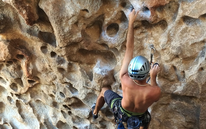 a person wearing safety gear scales a rock wall